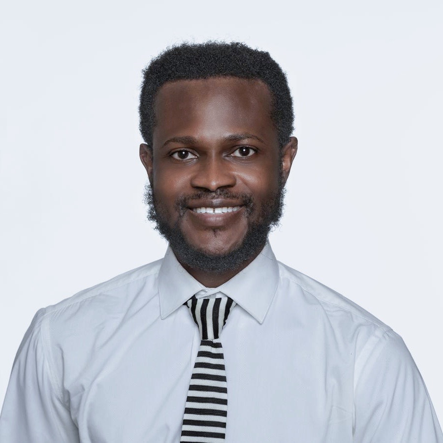 A portrait picture of Yaw wearing a white shirt ad a black and white stripes tie