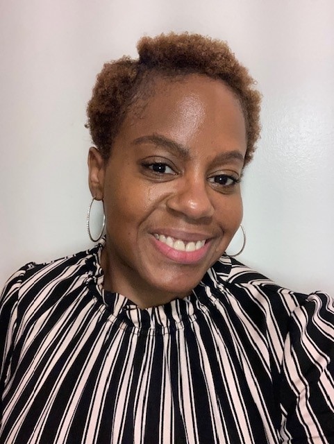 A portrait of Danielle. Danielle is wearing a brown stripes shirt